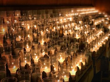 Row of illuminated candles in temple