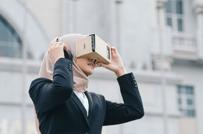 Young businesswoman using virtual reality simulator