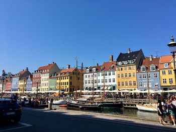 City street by buildings against blue sky