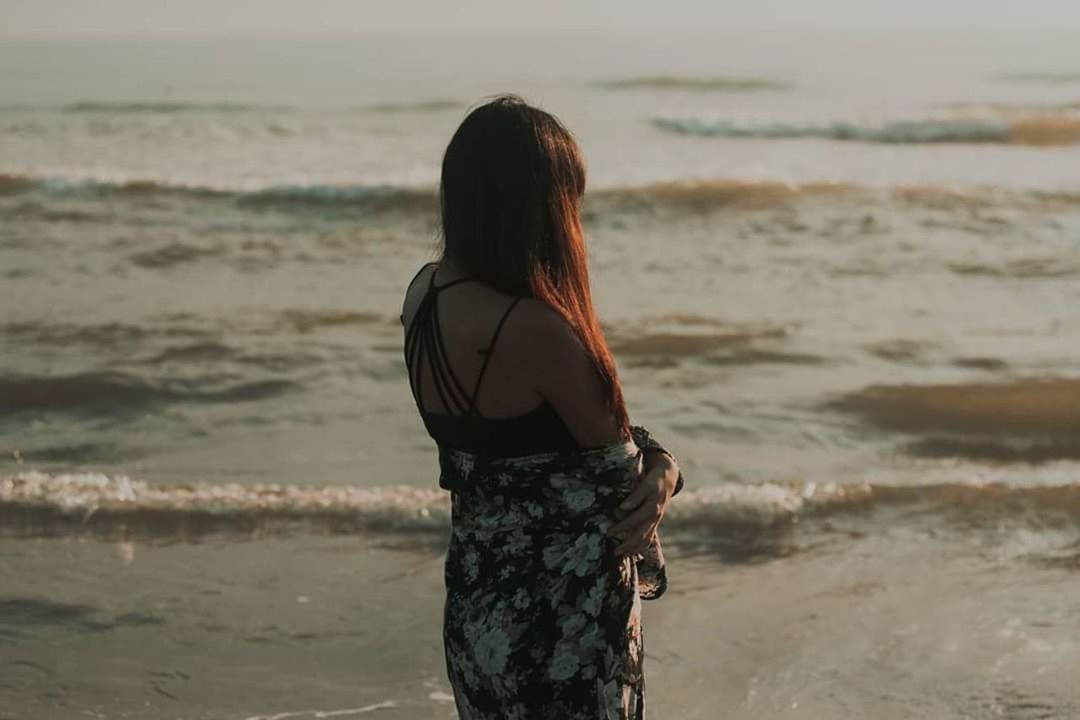rear view, beach, sea, water, young adult, only women, lifestyles, three quarter length, long hair, one young woman only, one person, wave, leisure activity, one woman only, adult, young women, standing, outdoors, adults only, horizon over water, sand, people, day, nature