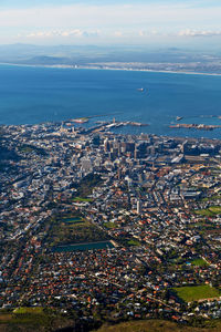 High angle view of city by sea against sky