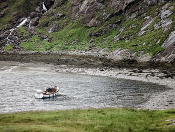 People sitting on riverbank by river