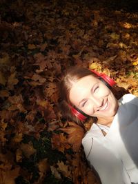 Portrait of a smiling young woman with autumn leaves