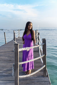 Portrait of young black woman standing against the sea
