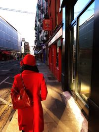 Rear view of woman in city against sky