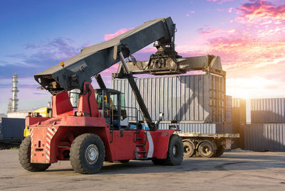 Crane loading cargo container at dock