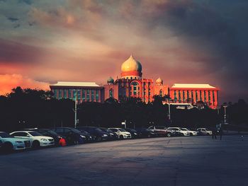 View of cars on road against cloudy sky