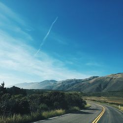 Empty road along landscape and mountains against sky