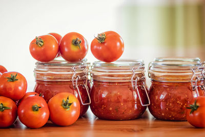 Close-up of tomatoes in glass container on table