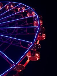 Low angle view of illuminated ferris wheel against sky at night