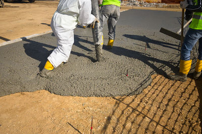 Construction workers dressed in uniform pour a concrete. cement works on a construction site