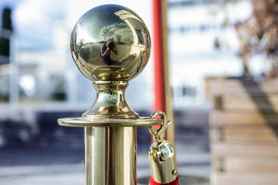 Reflection of man in golden railing