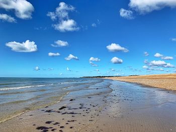 Scenic view of beach against blue sky