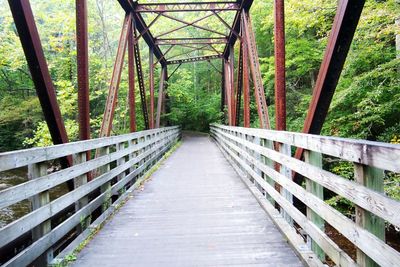 Footbridge amidst trees in forest