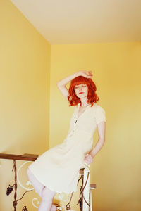 Portrait of woman standing against wall