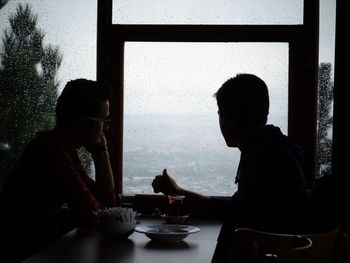 Silhouette of man and woman sitting in cafe