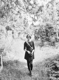 Full length of woman standing on tree trunk