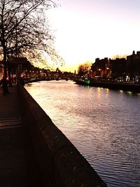 River by illuminated city against clear sky