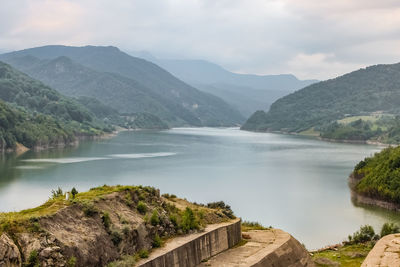 Scenic view of river and mountains against sky