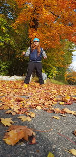 Low section of person standing by autumn leaves