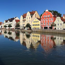 Reflection of buildings on river against sky