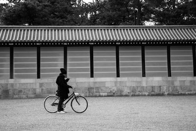 Full length of man with bicycle standing on road