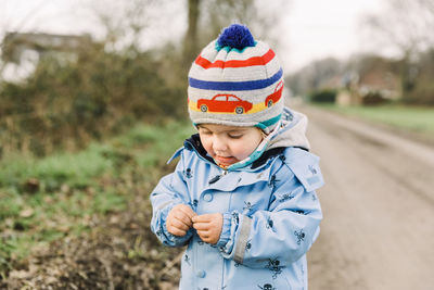 Boy wearing hat standing on field