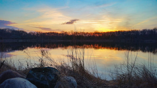 Scenic view of lake against sky at sunset