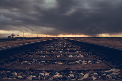 Surface level of railroad track against cloudy sky