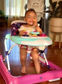 Portrait of smiling girl sitting on baby walker