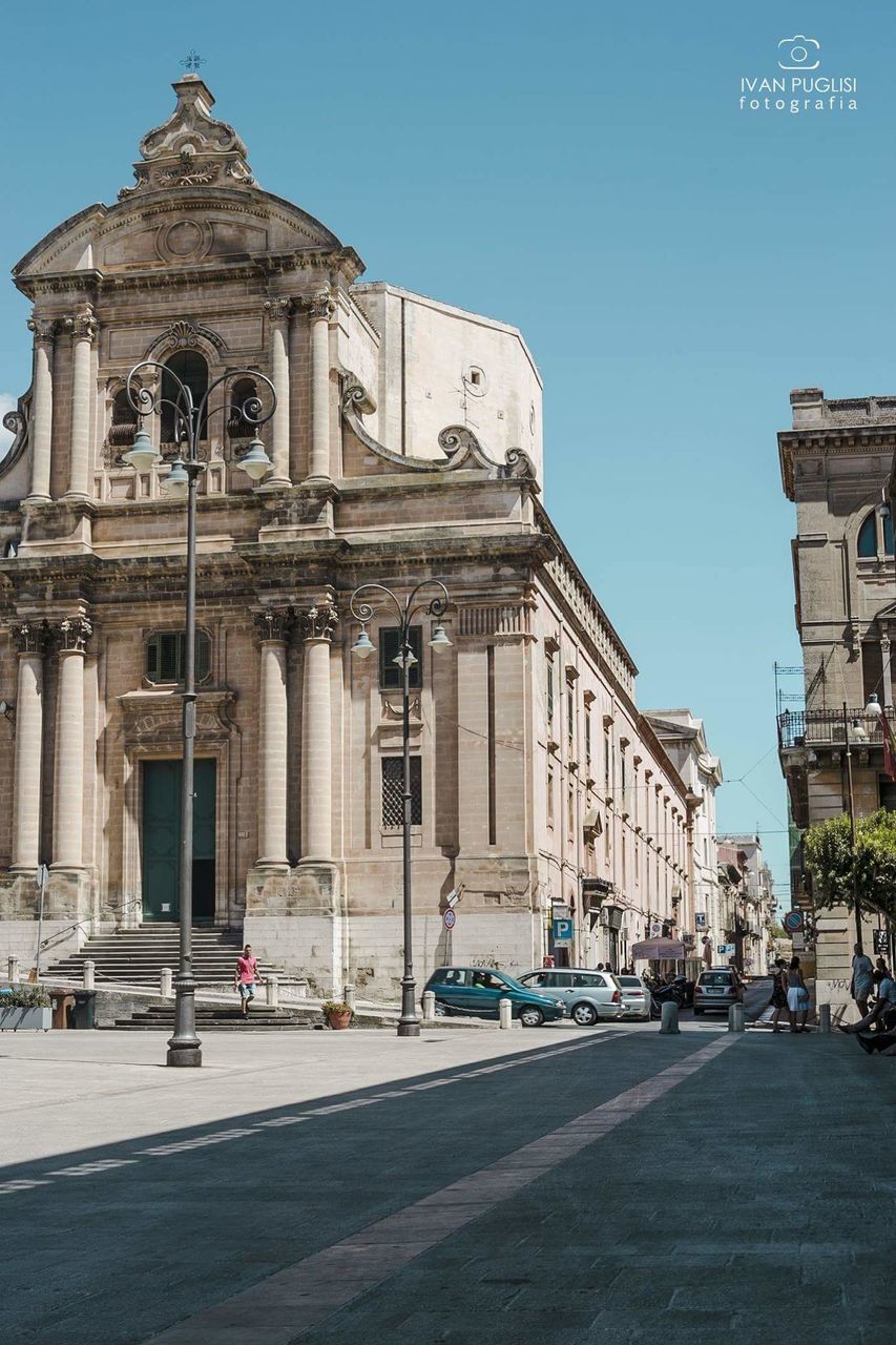 STREET BY BUILDING AGAINST CLEAR SKY