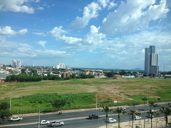 Road by buildings against sky in city