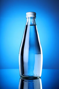 Close-up of glass bottle against blue background