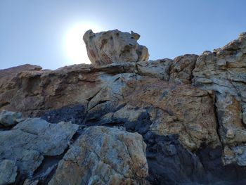 Low angle view of rock formation against clear blue sky