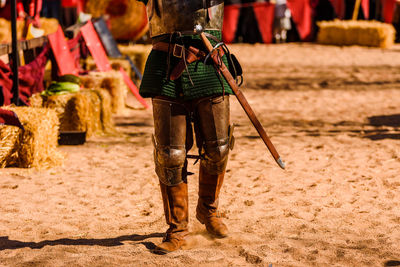 Low section of man standing on sand