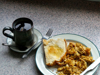 Overhead view of eggs and toast breakfast with mug of tea