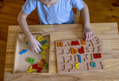 Directly above shot of boy playing with alphabets