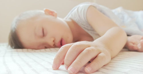 Close-up of baby sleeping on bed