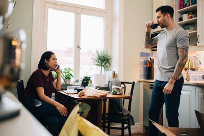 Young man using mobile phone while standing on table