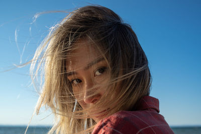Close-up portrait of girl against sky