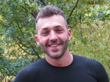 Portrait of smiling young man against plants