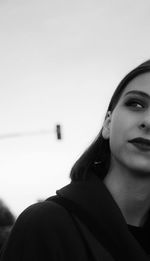 Close-up of young woman looking away against sky