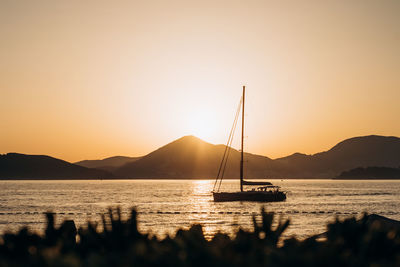 Silhouette sailboats in sea against sky during sunset