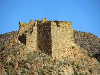 Low angle view of fort against clear blue sky