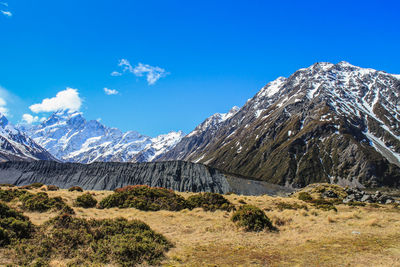 Scenic view of snowcapped mountains against blue sky