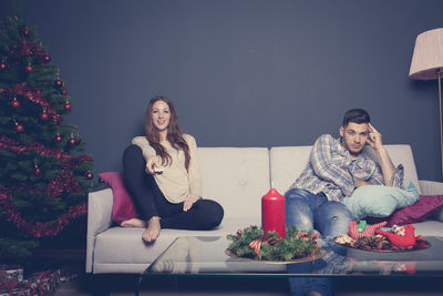 Young woman sitting on sofa at home