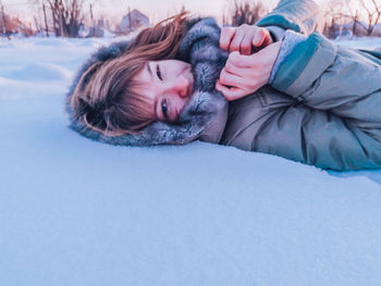 Portrait of woman sleeping in snow