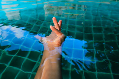 Midsection of person swimming in pool