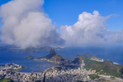 Aerial view of townscape by sea against sky