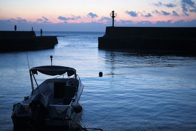 Silhouette boat in sea against sky during sunset